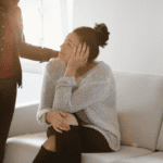A woman comforting another woman.