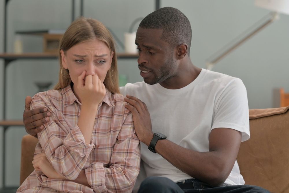 Willow Creek - What Is the Ripple Effect of Mental Health Disorders - Edited. A young woman sits nervously while a man consoles her.
